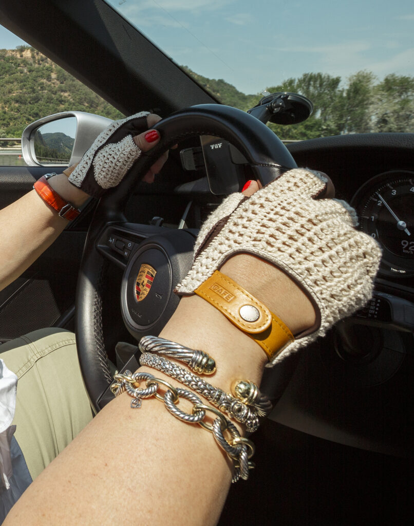 A woman's hands at the wheel of a Porsche 911