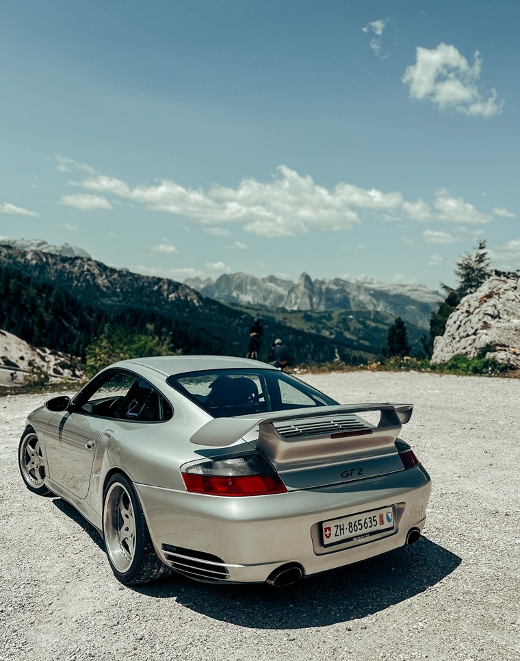 Porsche 996 GT2 is parked at a viewpoint near the Passo Falzarego in the Dolomite Alps in Italy